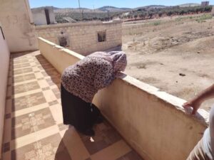 صورة: امرأة كردية من عفرين تقبل جدران منزلها عقب عودتها إلى منطقة عفرين بعد عملية تهجير قسري دامت أكثر من 7 سنوات